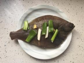 鱼身抹盐和料酒，覆盖葱姜。腌制20分钟