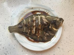 蒸好后将鱼盘端出，倒掉盘子里的水，葱段姜片挑出不要