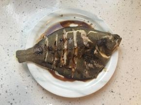 蒸好后将鱼盘端出，倒掉盘子里的水，葱段姜片挑出不要