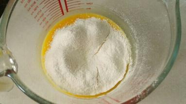 低筋面粉、玉米淀粉、泡打粉混合过筛到蛋液里