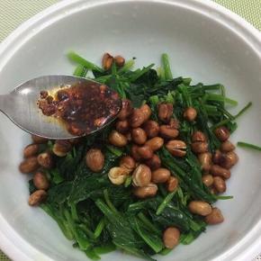 把调好的料汁倒入装有菠菜和花生米的碗中，搅拌均匀
