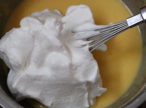 6.取3分之一的蛋白霜加入蛋黄糊中切拌均匀后倒回到蛋白霜中切拌均匀
