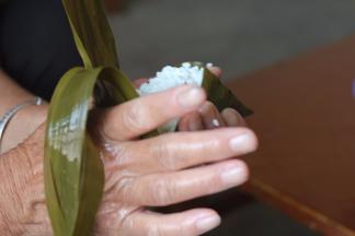 11.左手拿着粽子用你的右手向前推粽叶，盖上口