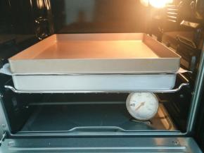 11.发酵好的面包取出刷牛奶，撒上黑芝麻，盖上油纸压上一个平烤盘，烤箱170度20分钟（中下层）烤好后取出放凉即可