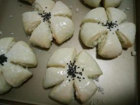 13.发酵好的面团取出刷一层牛奶，在花朵中间撒上黑芝麻