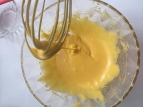 再把蛋黄倒入盆里，再用刮刀搅拌混合均匀就好，混合到流动性的蛋黄糊即可，这样就已经把蛋黄糊做好放一边