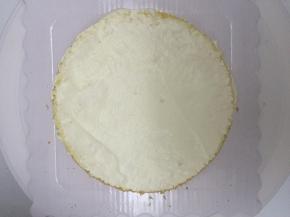 在裱花台上放上第一片蛋糕，在蛋糕表面涂上奶油