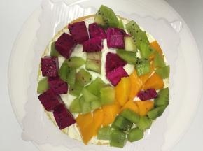 再盖上第二片蛋糕再涂上奶油，夹上水果，