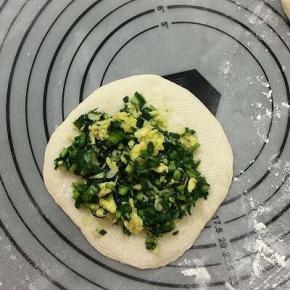 擀成圆片，中间放上韭菜馅