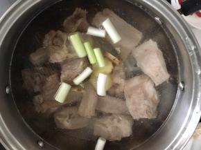 锅内倒入适量的水（水位高于排骨两倍左右，根据个人口味添加）盐和葱段还有姜片，开大火煮