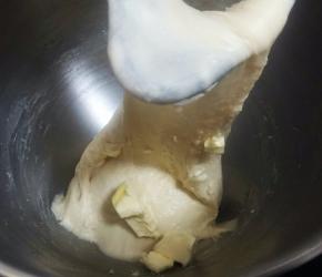 除黄油、芝麻外的所有材料放入厨师机（我用的是海氏HM770），用1档揉成团后，换3档揉至扩展阶段，加入软化的黄油。