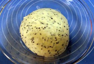 加入熟芝麻揉匀，盖上保鲜膜，放温暖处发酵。