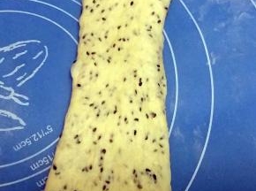 将松驰好的面团，收口朝上，擀长，面团边上的气泡用手拍掉；