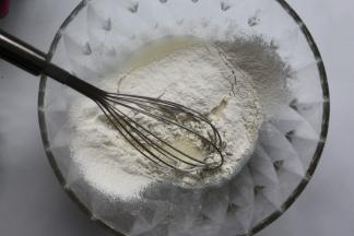 将低筋面粉过筛到搅拌好的牛奶油糊里，用手动打蛋器以Z字型方式搅拌到无干粉即可