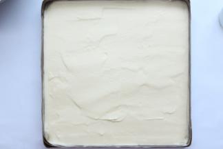 将面糊在离桌面20公分高的地方慢慢倒入金盘中，借助刮刀，将面糊平均滩平在盘子里