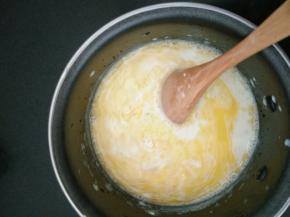 2.取出香草荚牛奶，再次加热至温热后离火，放入黄油至融化，放凉备用