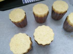 10.送入预热好的烤箱中层230度25分钟转180度50分钟.烘烤过程中，可露丽面糊会膨胀高出模具，这个时候要戴上隔热收到，取出烤盘让模具降温，轻敲模具，使面糊回到模具内，才不会产生白头翁的现象（只要是膨胀出烤箱的高度就要轻敲下去）