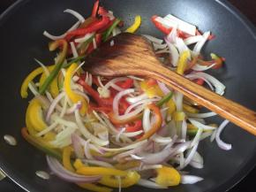 青椒、红黄彩椒、白紫洋葱切丝后放入锅里炒香