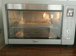 6.倒入垫有油纸的烤盘里振动气泡入烤箱180度18-20分钟出炉振动模具，取出来倒扣撕掉油纸，再盖一层油纸