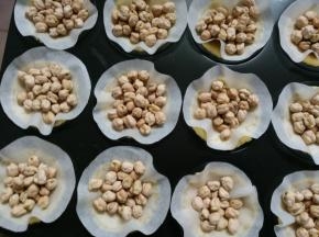 8.把处理好的油纸放入面团上 压上豆子 