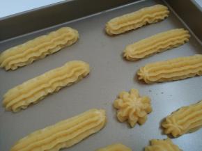 8.挤到烤盘上，注意每个泡芙之间要适当留以空隙，防止在烤箱里膨胀后粘在一起。在干净的双手沾上凉水，用指尖将泡芙上下方的尖尖角压平。