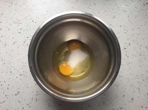 鸡蛋打入盆中,加入白砂糖