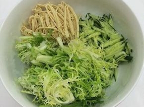 拿个大碗将洗干净的黄瓜和干豆腐切成细丝，苦菊切成小段