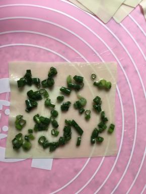 擀好的云吞皮刷少许油，撒少许盐，撒上葱花