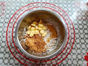 取一只干净的盆子，倒入麦片，花生，低筋面粉，红糖粉，黄油