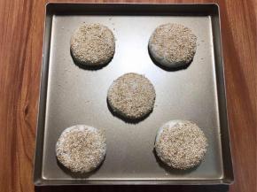 翻过来，轻按扁，用手团一团，然后表面轻刷点水，粘一点熟白芝麻，烤箱预热180度，20分钟。