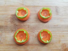 胡萝卜切成原片，把青椒放在胡萝卜片上用牙签画出需要的胡萝卜轮廓