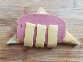 先把吐司面上的一块取下，放上火腿肠片和芝士条