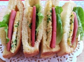 在土司里放上蛋饼，火腿肠片和生菜，口袋三明治就做好了