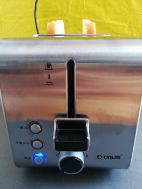 把2块面包片放入多士炉，选择一档模式按下开关