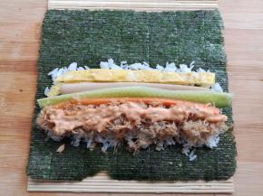 在米饭上放上鸡蛋条，黄瓜，胡萝卜，火腿肠和肉松，在肉松上挤上适量的千岛酱