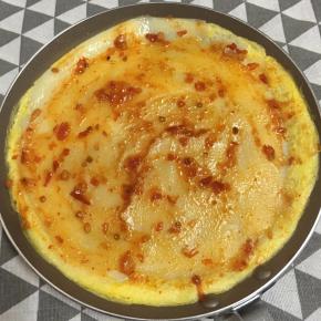 翻面，将鸡蛋饼煎熟，抹上辣椒酱即可食用。