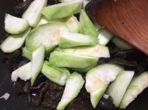 炒至水分微干，下入丝瓜翻炒。