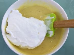 取三分之一的蛋白霜到蛋黄糊里，翻拌均匀。