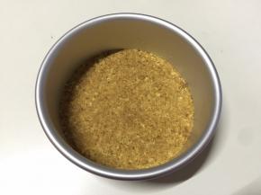 隔水融化50克黄油，倒入饼干碎中拌匀，倒入底部已经垫好油纸的6寸活底模具中，用小刮刀或小勺子压平黄油饼干碎，使其紧实，送进冰箱冷藏30分钟