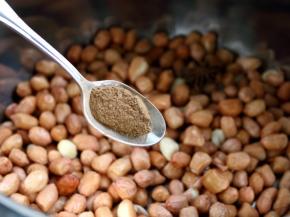 将花生米入锅，加入适量的五香粉。