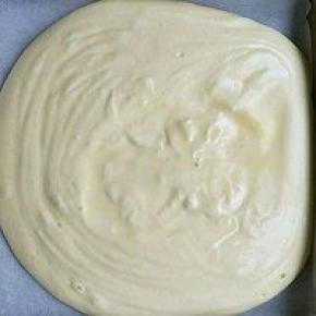 舀1/3的蛋白倒入面糊中略拌匀，在迅速倒入蛋白霜中翻拌均匀。完成的面糊细腻有光泽。倒入放了油纸的烤盘里