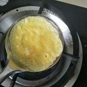 开小火大勺子抹上植物油倒入蛋液，转动勺子转满尽量薄厚均匀。