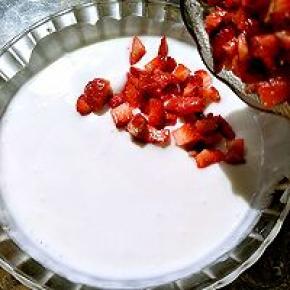 切好的草莓倒入搅拌好的酸奶里。