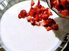 切好的草莓倒入搅拌好的酸奶里。