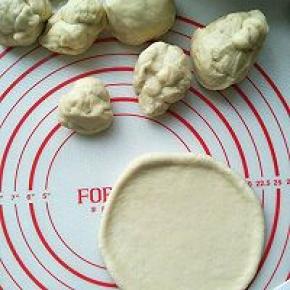 取出发好的面团排气，分成大小不一的八个面团，分别滚圆，在分别擀成圆片。