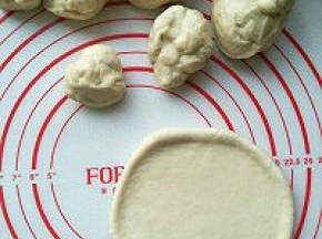 取出发好的面团排气，分成大小不一的八个面团，分别滚圆，在分别擀成圆片。