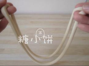 取其中一根面对折，如图示用两手捏着两端边敲打台面边抻拉