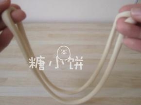 取其中一根面对折，如图示用两手捏着两端边敲打台面边抻拉