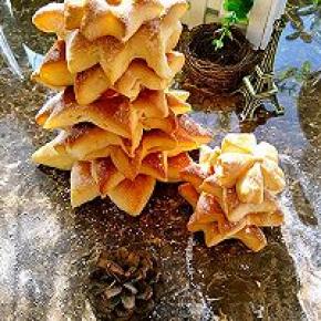 烤好的面包放在晾网上放凉，从大到小层层往上叠加起来，最后那个小的竖着放在最上面，圣诞面包树就做好了