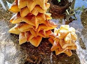 烤好的面包放在晾网上放凉，从大到小层层往上叠加起来，最后那个小的竖着放在最上面，圣诞面包树就做好了